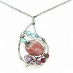 smooth rhodochrosite, pink fresh water pearl, pink tourmaline, moonstone, and larimar gemstones fill the inside of a floral stamped and hammered sterling silver necklace 