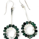 Handmade hammered sterling silver rings are outlined with faceted emerald gemstones hanging from a sterling silver hammered and twisted bar, accented with a silver fresh water pearl dangle