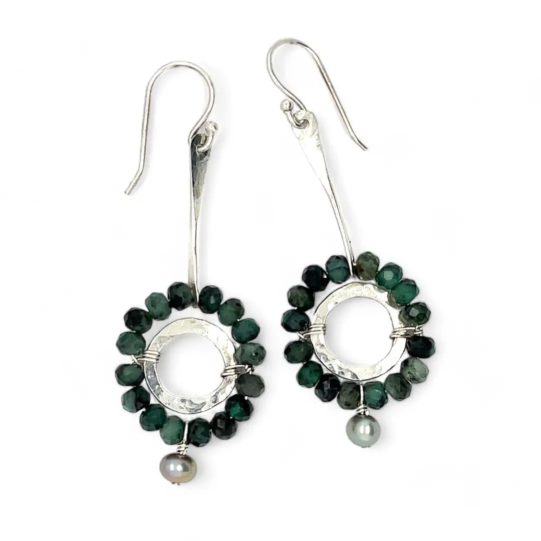 Handmade hammered sterling silver rings are outlined with faceted emerald gemstones hanging from a sterling silver hammered and twisted bar, accented with a silver fresh water pearl dangle