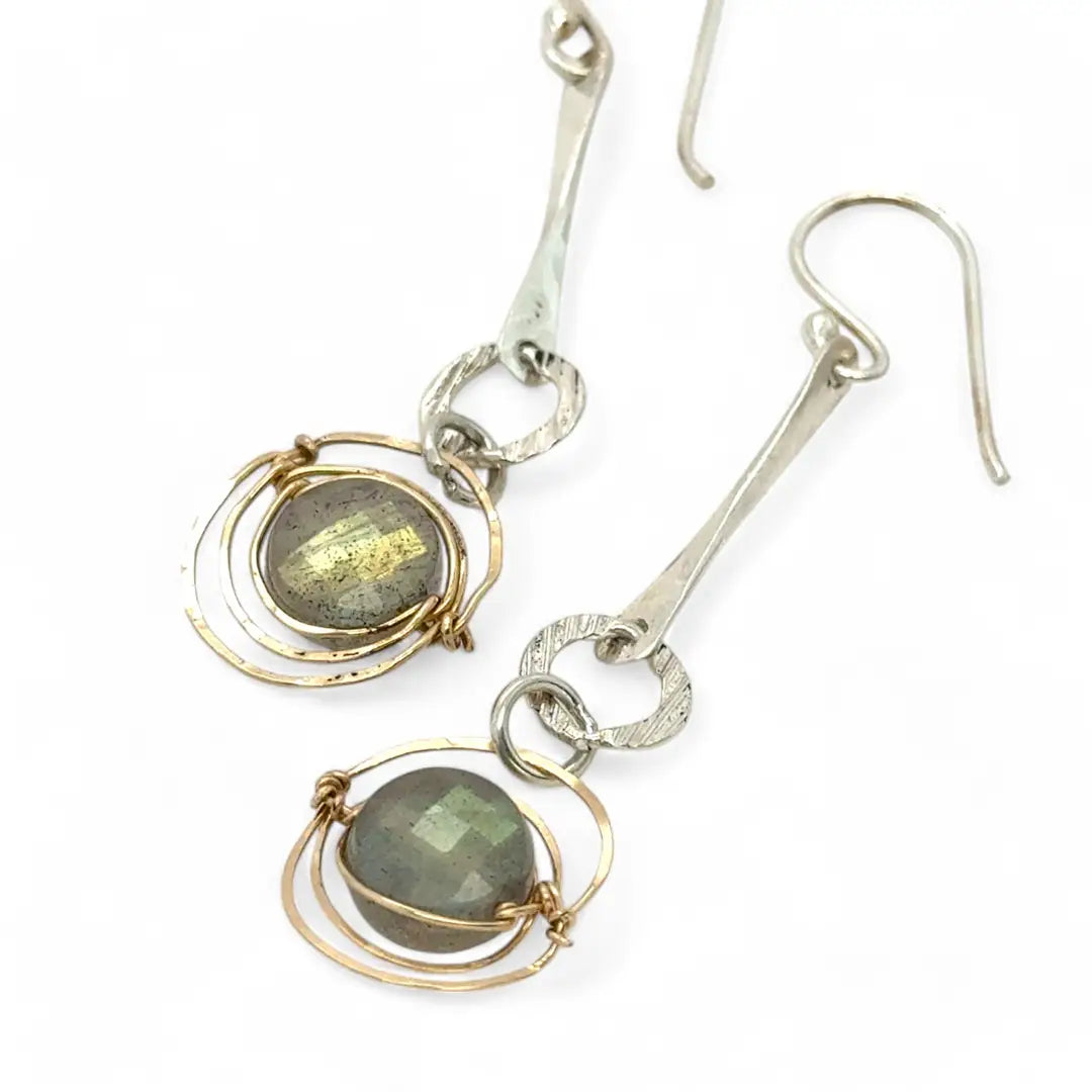 Flashy labradorite faceted coins wrapped in layers of gold filled wire hanging from a hand formed sterling silver twisted bar earring
