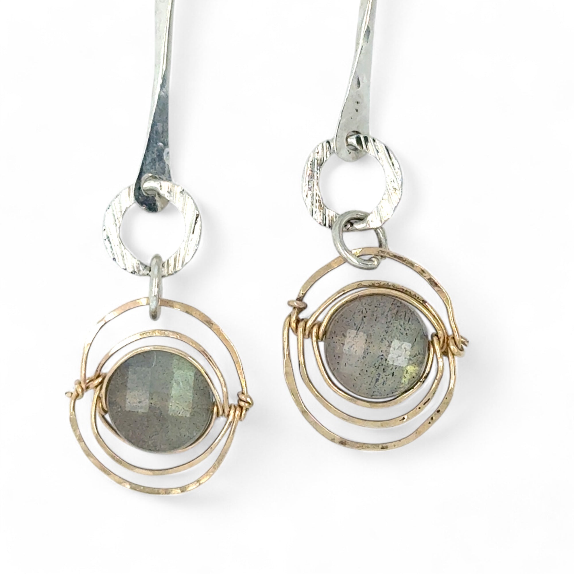 Flashy labradorite faceted coins wrapped in layers of gold filled wire hanging from a hand formed sterling silver twisted bar earring