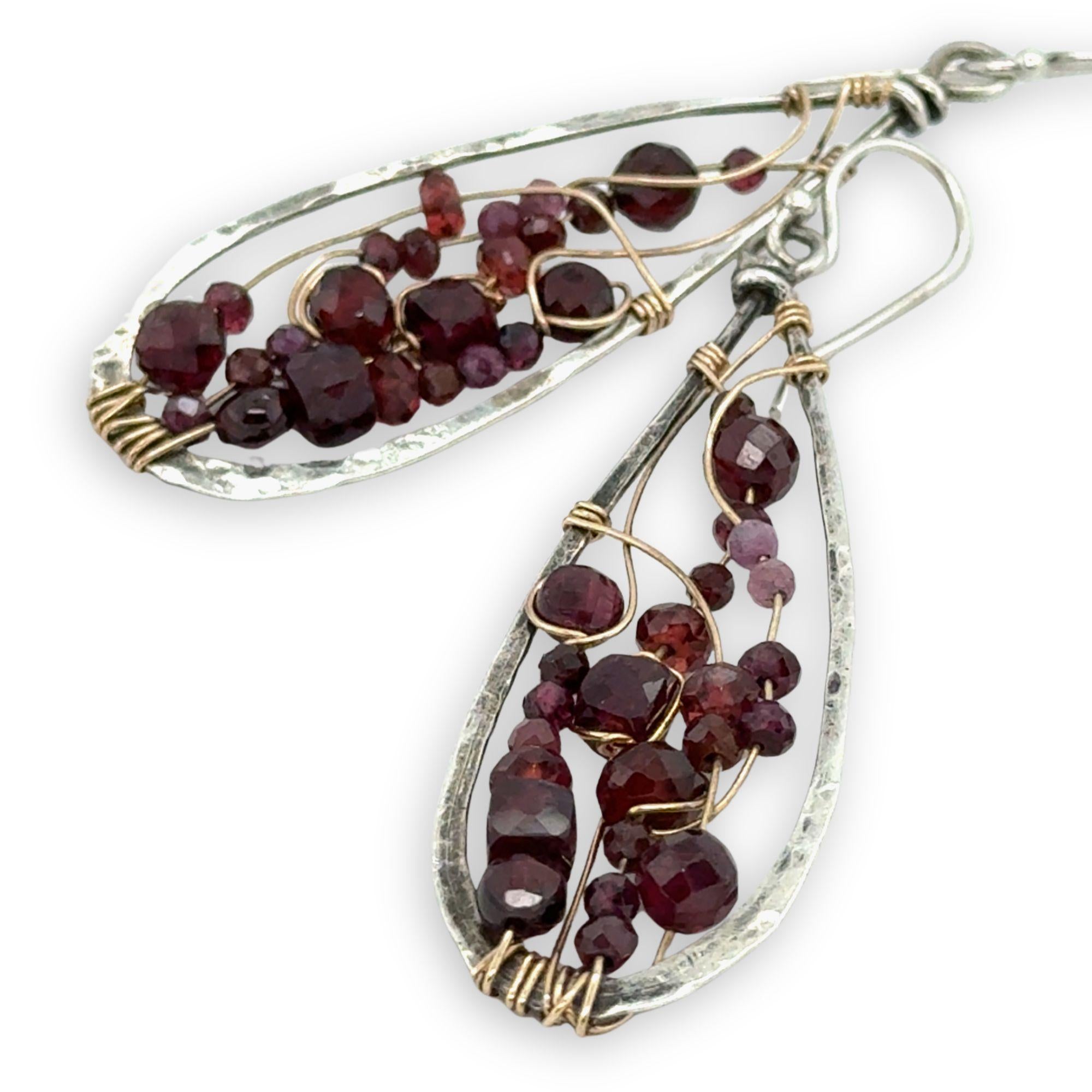 darkened sterling silver drop earrings embroidered with a variety of faceted garnet gemstones in gold filled wire