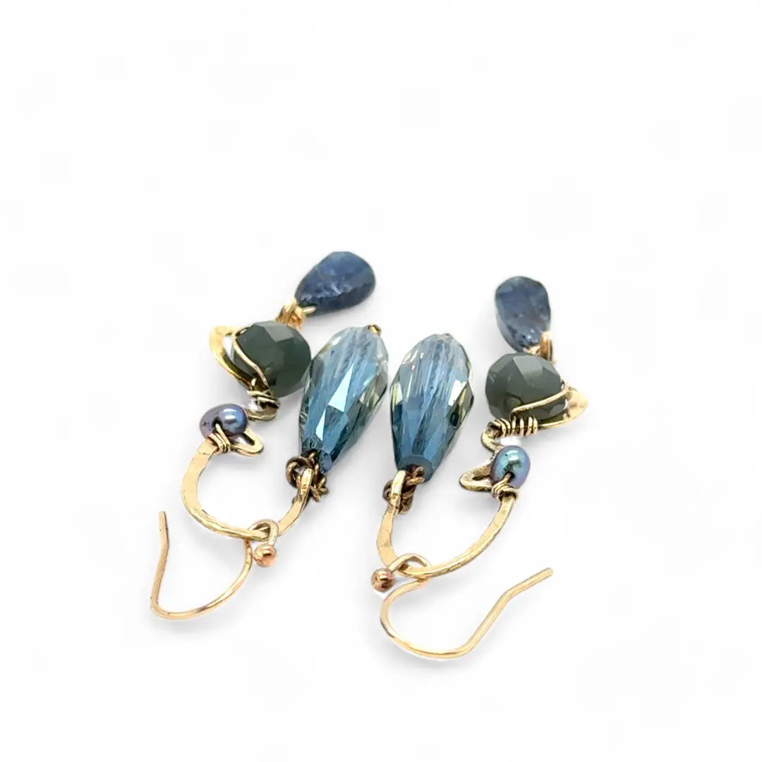 A pair of brass sculptural squiggle earrings with raw kyanite gemstone drops, an assortment of sparkly crystals, and fresh water pearls, featuring gold-filled French hooks.