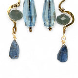 A pair of brass sculptural squiggle earrings with raw kyanite gemstone drops, an assortment of sparkly crystals, and fresh water pearls, featuring gold-filled French hooks.