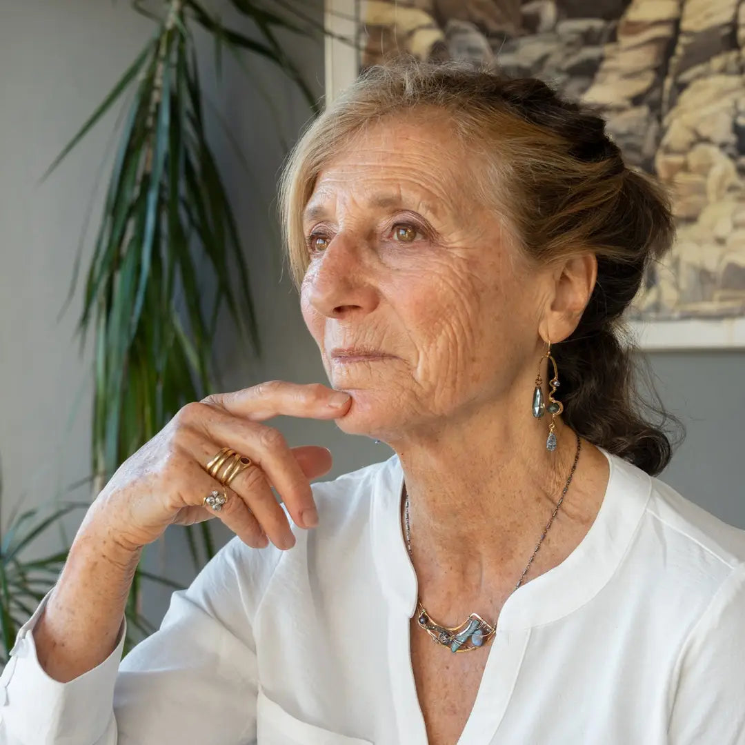 A pair of brass sculptural squiggle earrings with raw kyanite gemstone drops, an assortment of sparkly crystals, and fresh water pearls, featuring gold-filled French hooks.