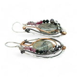 A pair of Prehnite smooth oval earrings with cool inclusions, adorned with hammered bronze, twisted oxidized sterling silver, and micro faceted watermelon tourmaline gemstones, attached to sterling silver French hooks.