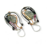 A pair of Prehnite smooth oval earrings with cool inclusions, adorned with hammered bronze, twisted oxidized sterling silver, and micro faceted watermelon tourmaline gemstones, attached to sterling silver French hooks.