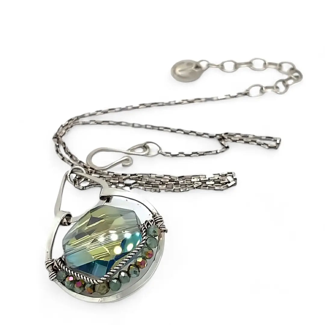 A sterling silver necklace with a box chain and an oval citrus crystal pendant, surrounded by smaller faceted crystals.
