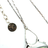 A sterling silver necklace with a box chain and an oval citrus crystal pendant, surrounded by smaller faceted crystals.