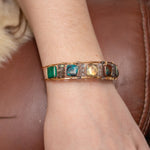 Chrysocolla and flashy labradorite tile gemstones are held within a brass cuff bracelet frame with oxidized sterling silver and gold filled wire accents