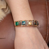 Chrysocolla and flashy labradorite tile gemstones are held within a brass cuff bracelet frame with oxidized sterling silver and gold filled wire accents