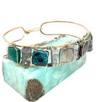 Chrysocolla and flashy labradorite tile gemstones are held within a brass cuff bracelet frame with oxidized sterling silver and gold filled wire accents