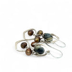 A pair of sterling silver chandelier earrings with brown fresh water pearl dangles and a central cat's eye faceted gemstone.