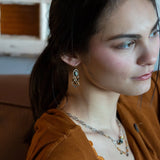 A pair of sterling silver chandelier earrings with brown fresh water pearl dangles and a central cat's eye faceted gemstone.