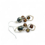 A pair of sterling silver chandelier earrings with brown fresh water pearl dangles and a central cat's eye faceted gemstone.