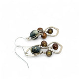 A pair of sterling silver chandelier earrings with brown fresh water pearl dangles and a central cat's eye faceted gemstone.