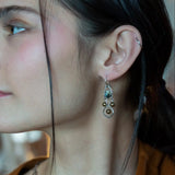 A pair of sterling silver chandelier earrings with brown fresh water pearl dangles and a central cat's eye faceted gemstone.