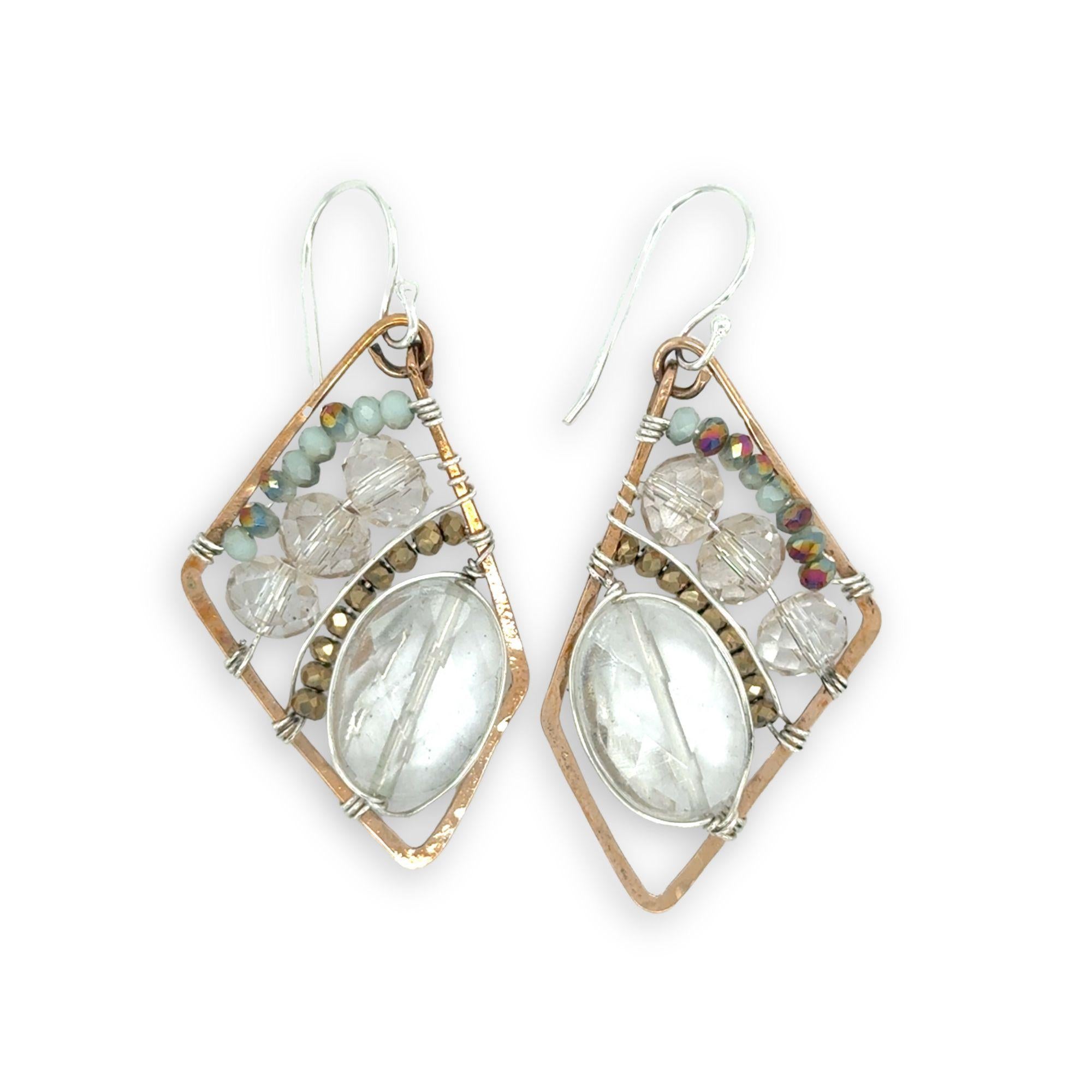 Quartz ovals surrounded by pyrite and crystal gemstones on sterling silver wire within a bronze parallelogram shape earrings