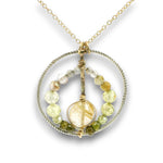 Sterling silver braided wire circle pendant filled with rutilated quartz and green cubic zirconia gemstones on gold filled wire and a 14k gold filled chain necklace