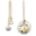 Sterling silver braided wire circle pendant filled with rutilated quartz and green cubic zirconia gemstones on gold filled wire and a 14k gold filled chain necklace