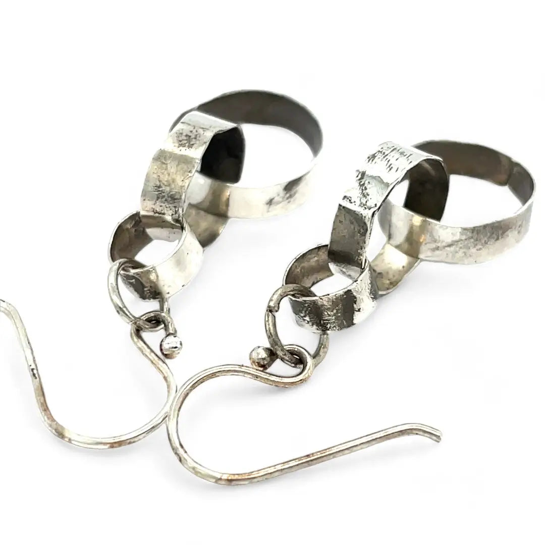Hammered darkened sterling silver handmade rings connected to each other to create a chain effect