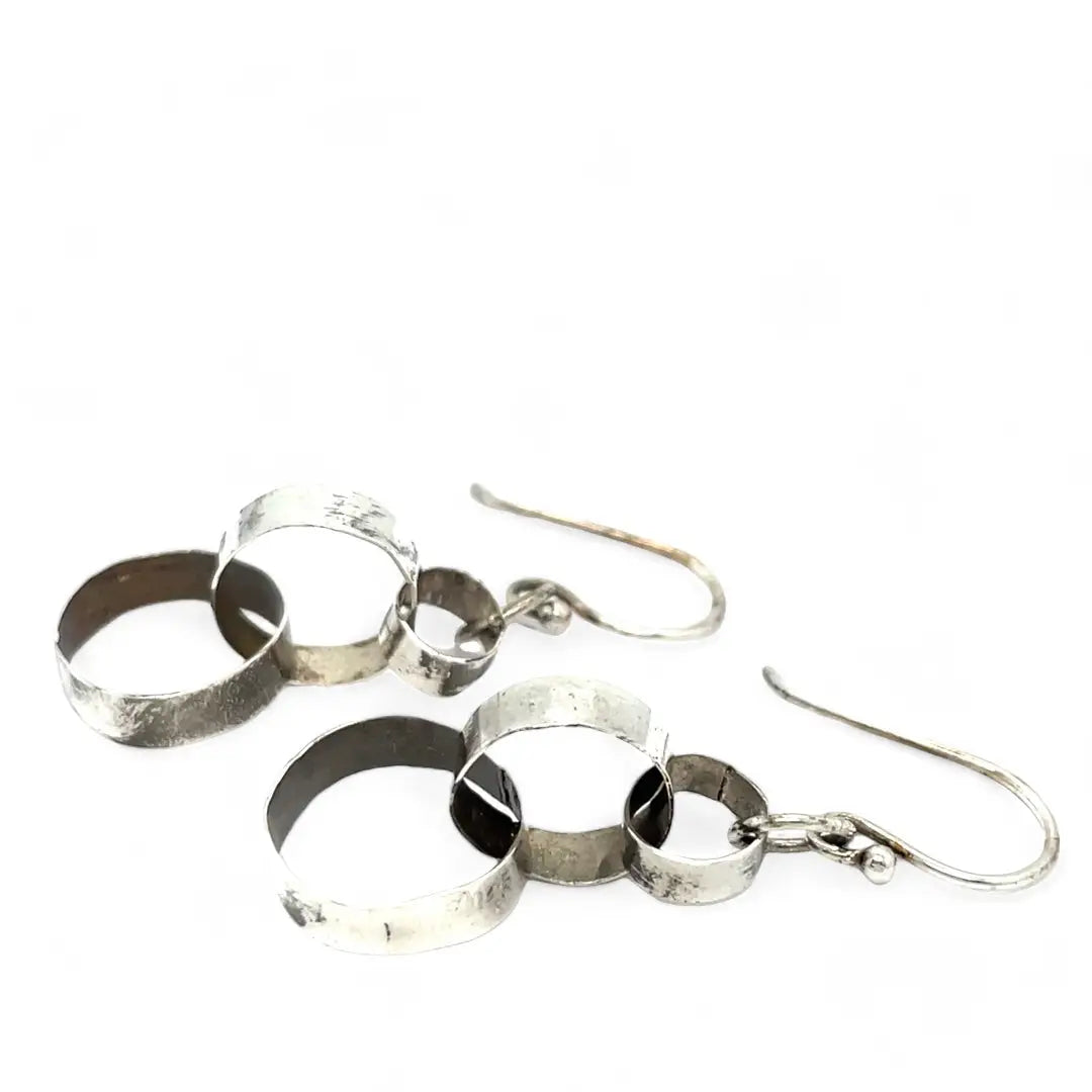 Hammered darkened sterling silver handmade rings connected to each other to create a chain effect