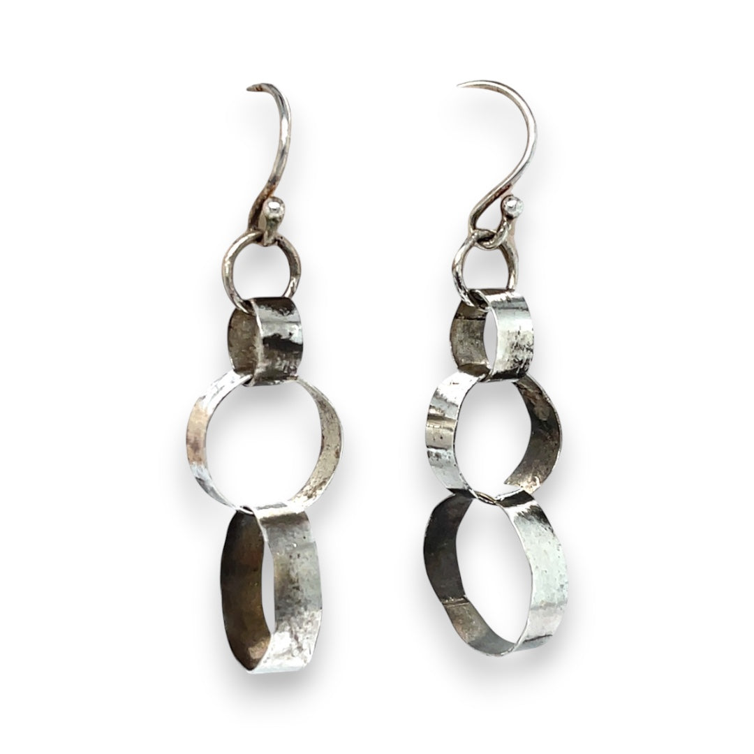 Hammered darkened sterling silver handmade rings connected to each other to create a chain effect