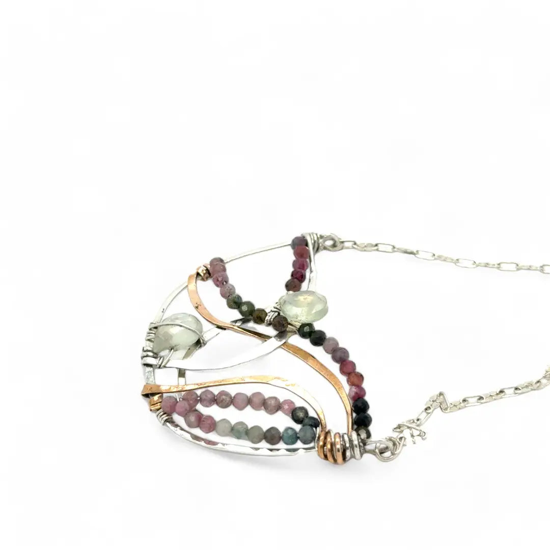 Two prehnite faceted gemstone drops are held within layers of mixed tourmaline, sterling silver, and bronze hammered metal to form our rainbows of tourmaline necklace
