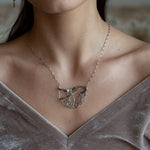 Two prehnite faceted gemstone drops are held within layers of mixed tourmaline, sterling silver, and bronze hammered metal to form our rainbows of tourmaline necklace