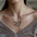 Two prehnite faceted gemstone drops are held within layers of mixed tourmaline, sterling silver, and bronze hammered metal to form our rainbows of tourmaline necklace