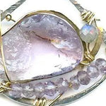 raw amethyst nugget is held in brass and gold filled wire with faceted amethyst and labradorite gemstones accents all inside a sterling silver pendant pendant