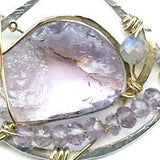 raw amethyst nugget is held in brass and gold filled wire with faceted amethyst and labradorite gemstones accents all inside a sterling silver pendant pendant