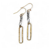 A pair of earrings featuring shiny brass rectangles attached to oxidized sterling silver chains, with gold filled French hooks.