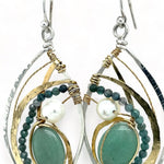 A pair of sterling silver marquise earrings with blue tourmaline gemstones, fresh water pearl, and jade set in hammered brass with silver french hooks.