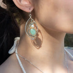 A pair of sterling silver marquise earrings with blue tourmaline gemstones, fresh water pearl, and jade set in hammered brass with silver french hooks.