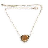 A large, smooth citrine nugget sits at the center of a brass hammered pendant necklace, with pyrite accents