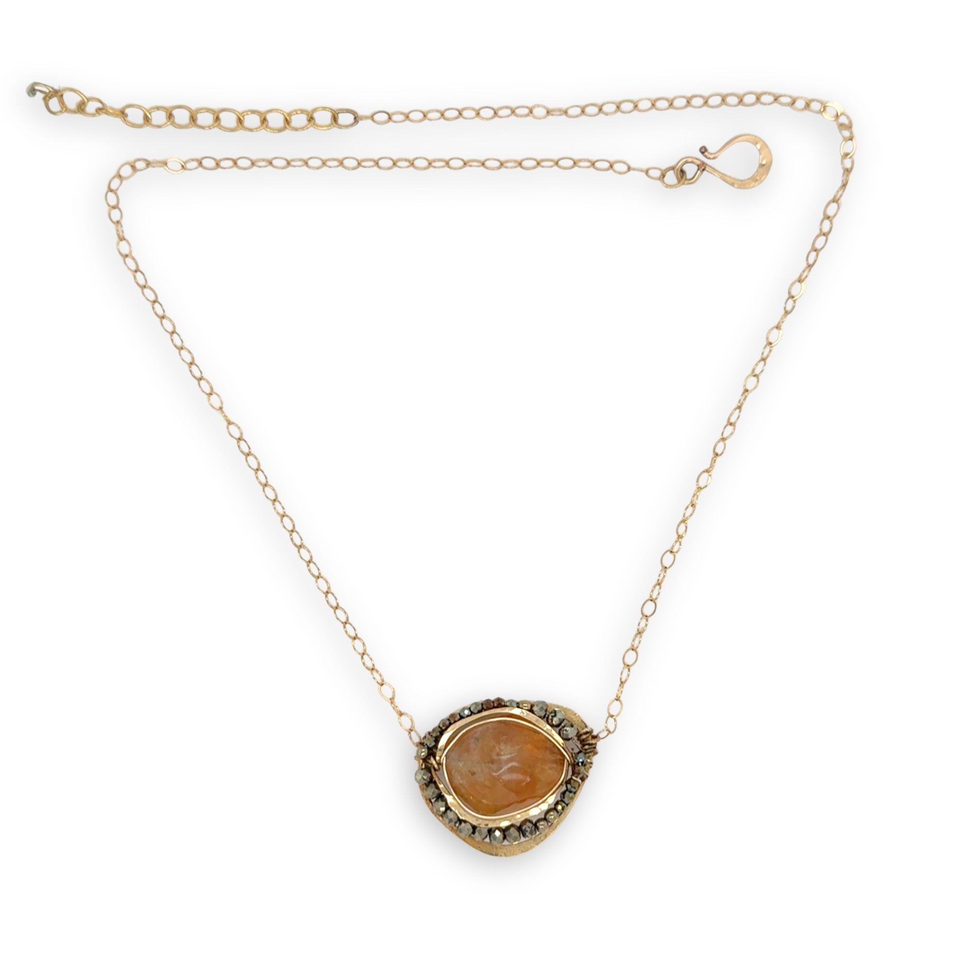 A large, smooth citrine nugget sits at the center of a brass hammered pendant necklace, with pyrite accents