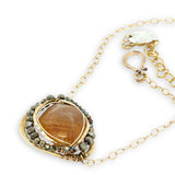 A large, smooth citrine nugget sits at the center of a brass hammered pendant necklace, with pyrite accents