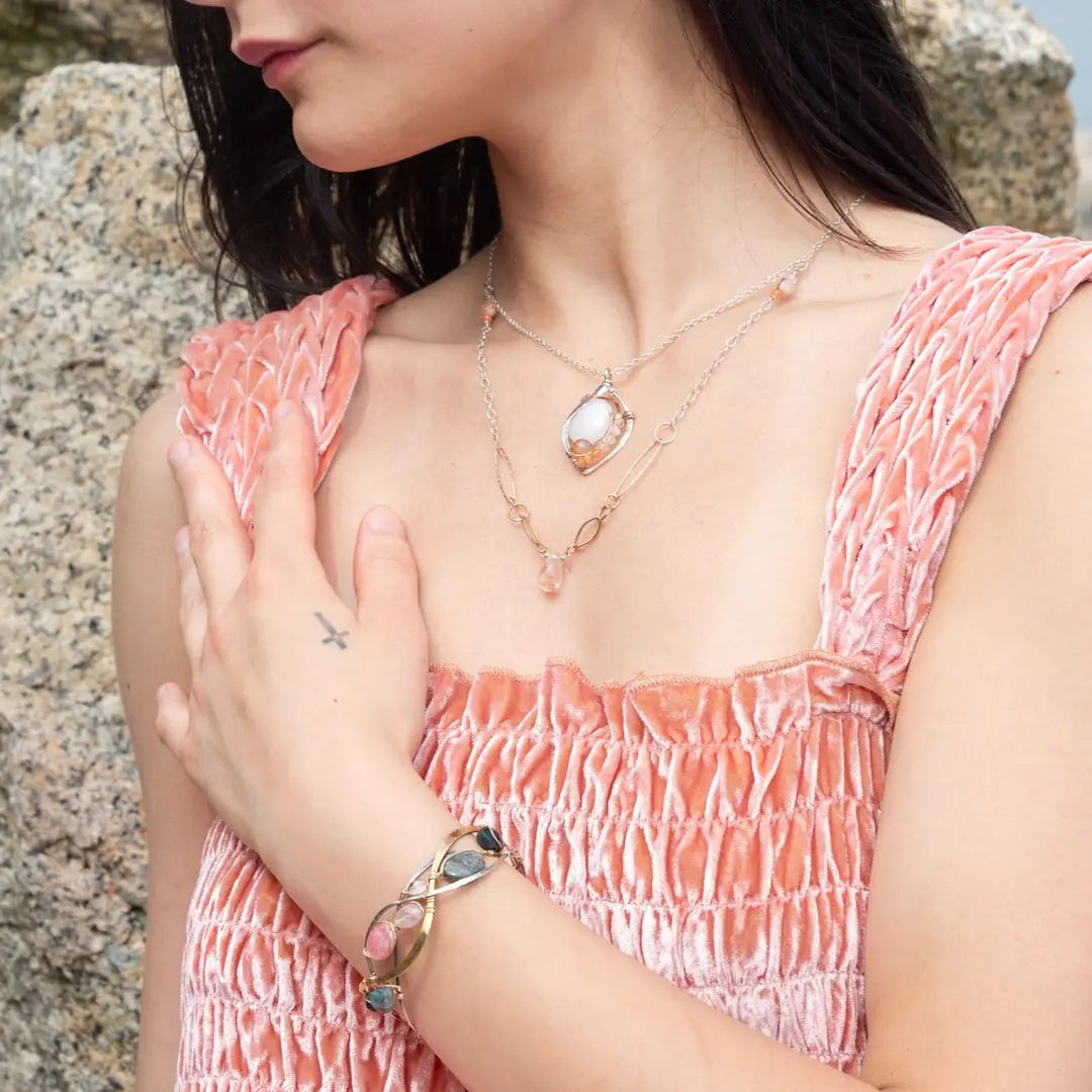 A oxidized sterling. brass, and sterling silver hammered wave bracelet featuring rhodochrosite, rose quartz, bloodstone, moss agate, and jasper gemstones on gold filled wire