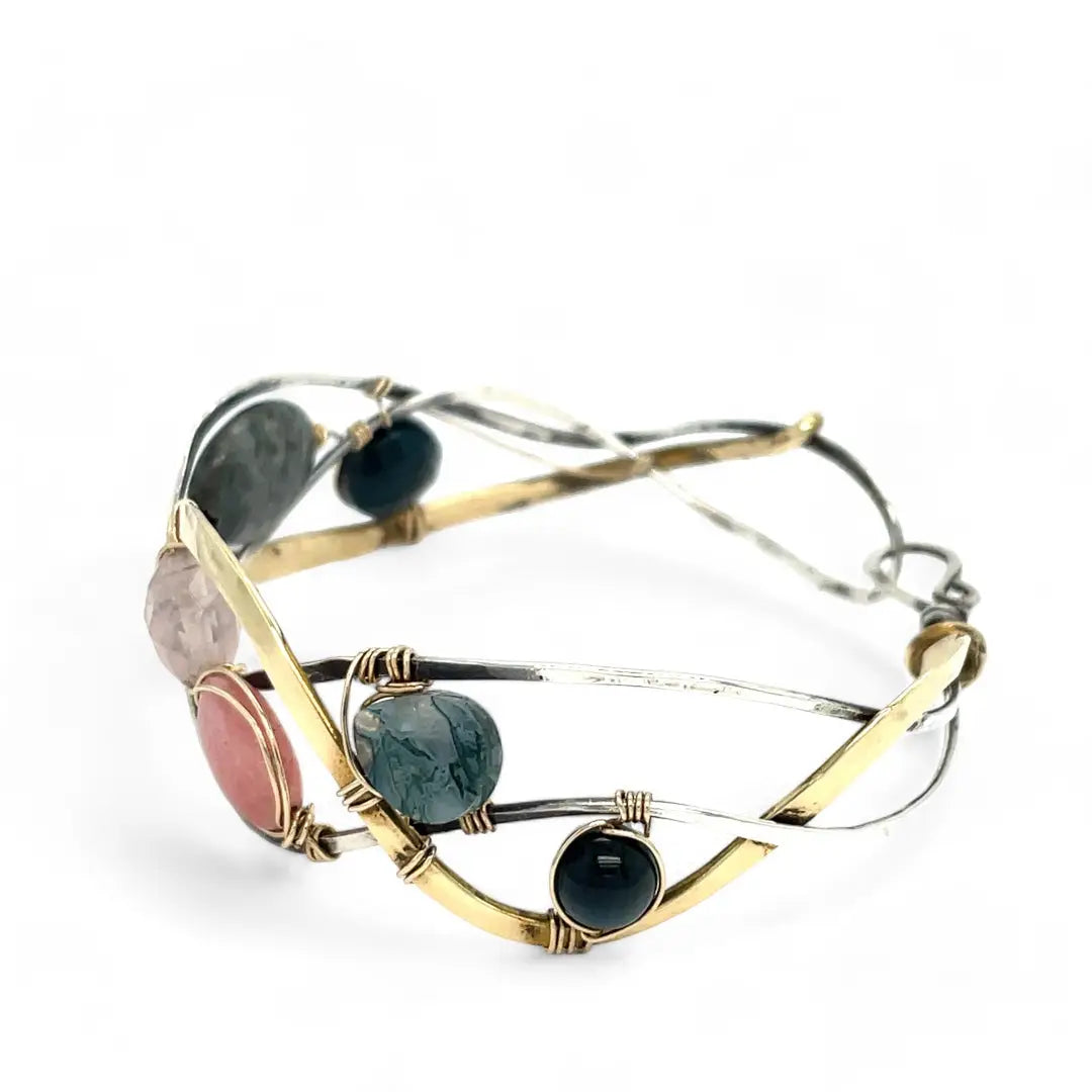 A oxidized sterling. brass, and sterling silver hammered wave bracelet featuring rhodochrosite, rose quartz, bloodstone, moss agate, and jasper gemstones on gold filled wire