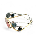 A oxidized sterling. brass, and sterling silver hammered wave bracelet featuring rhodochrosite, rose quartz, bloodstone, moss agate, and jasper gemstones on gold filled wire