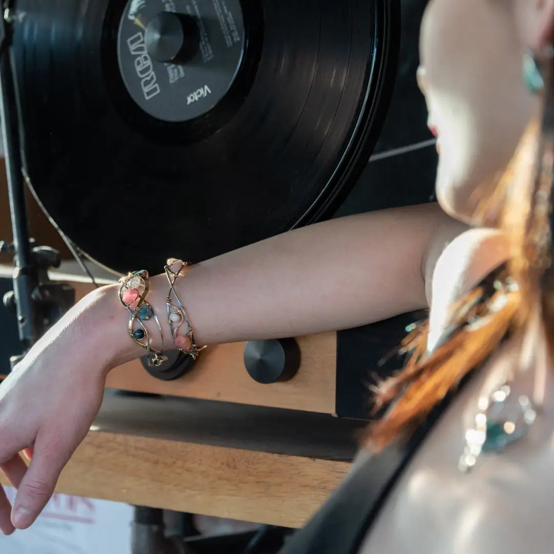 A oxidized sterling. brass, and sterling silver hammered wave bracelet featuring rhodochrosite, rose quartz, bloodstone, moss agate, and jasper gemstones on gold filled wire