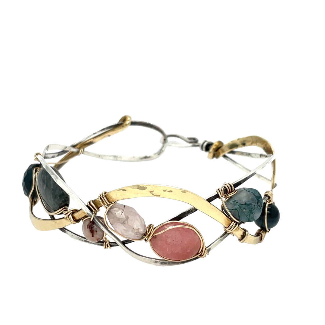 A oxidized sterling. brass, and sterling silver hammered wave bracelet featuring rhodochrosite, rose quartz, bloodstone, moss agate, and jasper gemstones on gold filled wire