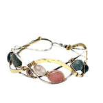 A oxidized sterling. brass, and sterling silver hammered wave bracelet featuring rhodochrosite, rose quartz, bloodstone, moss agate, and jasper gemstones on gold filled wire