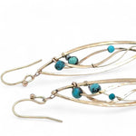 A pair of dangle bronze marquise earrings featuring hammered bronze and gold-filled designs with tiny faceted turquoise and chrysocolla gemstones.