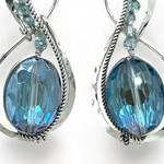 Pair of infinity shaped sterling silver earrings with blue crystal and apatite.