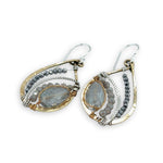 a light blue crystal drop wrapped in brass twist wire is surrounded by moonstone, pyrite gemstones, and hammered sterling silver hammered twist inside a mini brass teardrop earring