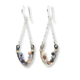 Horseshoe-shaped sterling silver earrings lined with sodalite blue and peach gemstones hanging on delicate silver chain