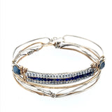 A slim handmade hammered sterling silver bracelet with bronze bars attached by lapis and blue quartz gemstones, on each side is accented with blue crystal drops and fresh water pearls