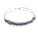 A slim handmade hammered sterling silver bracelet with bronze bars attached by lapis and blue quartz gemstones, on each side is accented with blue crystal drops and fresh water pearls